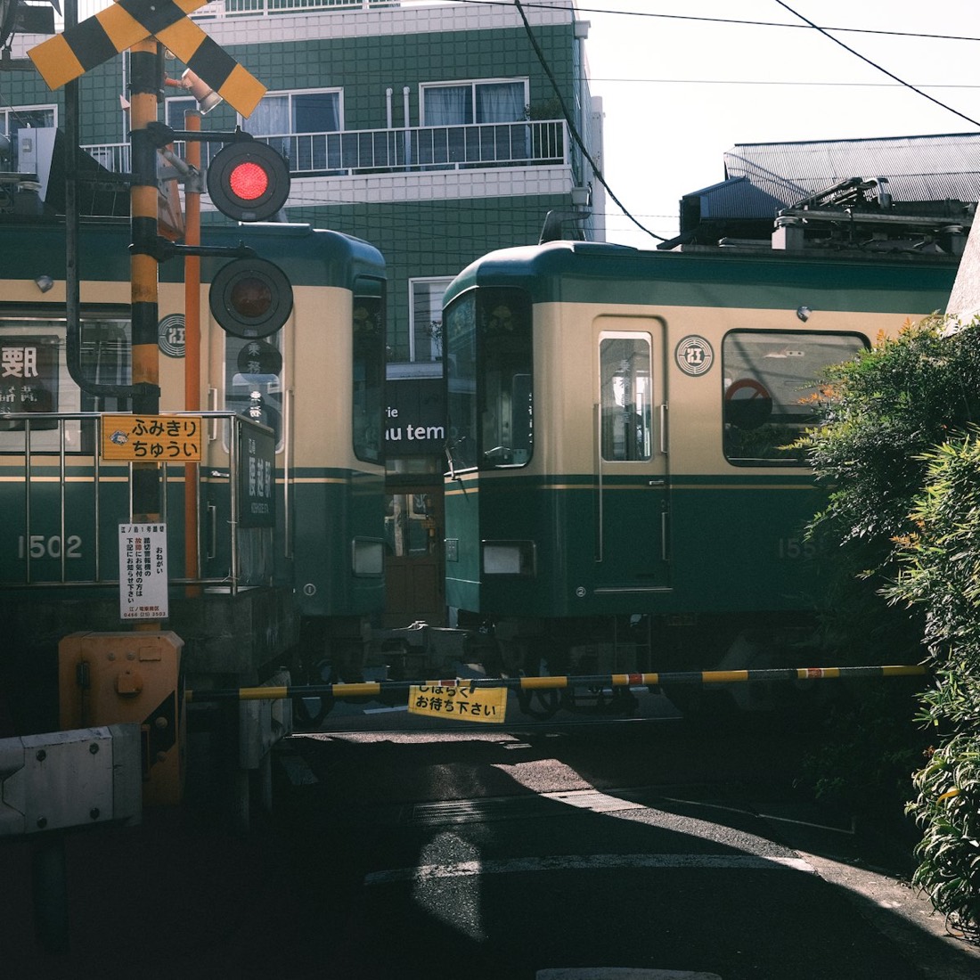 The Enoden train crossing a street by the sea in Kamakura